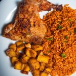 chicken with jollof rice, salad and fried plantains